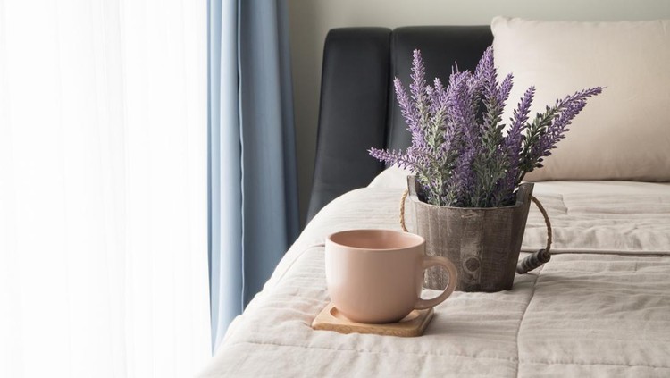 The bed with lavender flower and coffee cup in the morning, Selected focus on flower pot.