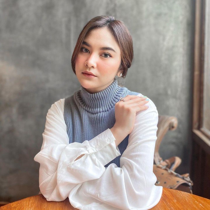 <p>Ingin yang lebih kalem untuk ke kantor ya, Bunda? Kalau gitu, Bunda bisa tiru gaya Mahalini yang mengenakan kemeja putih dengan<em> outer turtle neck</em> ini. (Foto: Instagram: @mahaliniraharja)</p>