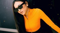 <p>Pakaian berwarna terang seperti<em> crop top</em> oranye ini bisa dipadukan dengan rok mini warna hitam, Bunda. Mahalini juga menambahkan kacamata hitam agar terlihat semakin <em>stylist</em>. (Foto: Instagram: @mahaliniraharja)</p>
