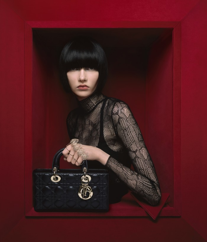Dari lini aksesori hadir versi terbaru dari tas ikonis Lady Dior yakni D-Joy. Bentuknya memanjang dengan detail Cannage dan charms yang khas. Foto: Brigitte Niedermair