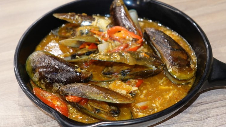 Ilustrasi Masakan Rumahan Variasi Seminggu Green scallops in Padang sauce on a black baking sheet