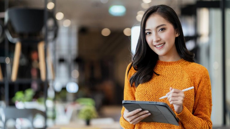 Ilustrasi Tes Kepribadian Sifat Dominan smart confidence asian female startup entrepreneur small business owner businesswoman wear smart casual cloth smile hand use tablet woking inventory checking in showroom office daytime background