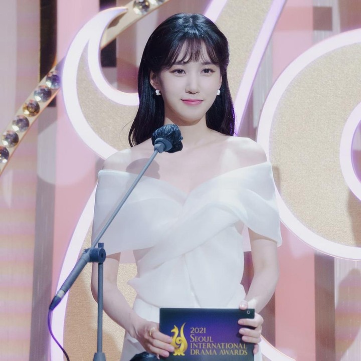 <p>Poni tersebut memiliki gaya potongan khas <em>Korean-look</em> yang tipis dan berjarak. Gaya tersebut membuatnya tampak lebih feminin, terutama ketika menjadi MC di acara <em>Seoul International Drama Awards 2021</em>. Ia mengenakan<em> sleeveless dress</em> berwarna putih lembut. (Foto: Instagram @eunbining0904)</p>