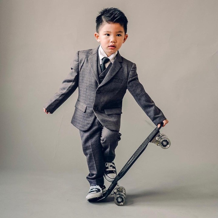 <p>Arthur juga tak kalah keren saat menggunakan setelan jas bernuansa hitam. Ia berpose dengan <em>skateboard</em>-nya bak seorang model cilik. (Foto: Instagram @arthurmiles.po)</p>