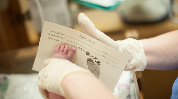 Ilustrasi Cap Kaki Bayi A newborn boy getting his footprints inked.