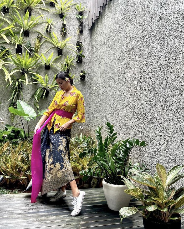 Ikut mengenakan pakaian tradisional Indonesia ini dalam keseharian, Titi Radjo Padmaja menampilkan gaya berbeda dengan kebaya Bali. Ia memadukannya dengan kain berdasar navy, selendang sebagai obi, dan Converse. Foto: instagram.com/titiradjopadmaja