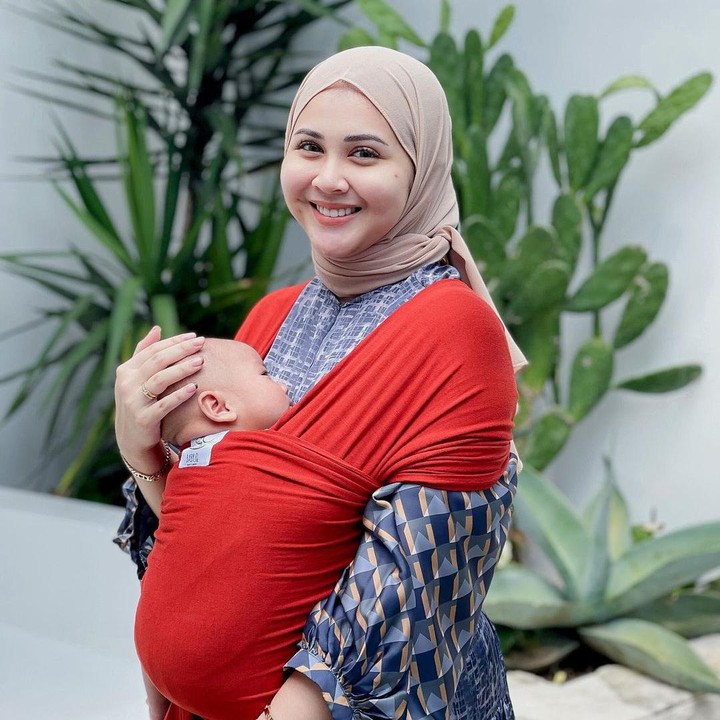 <p>Kesha Ratuliu menggunakan <em>baby wrap</em> warna merah nih, Bunda. Ia pun mengenakan pakaian dengan warna yang kontras. (Foto: Instagram: @kesharatuliu05)</p>