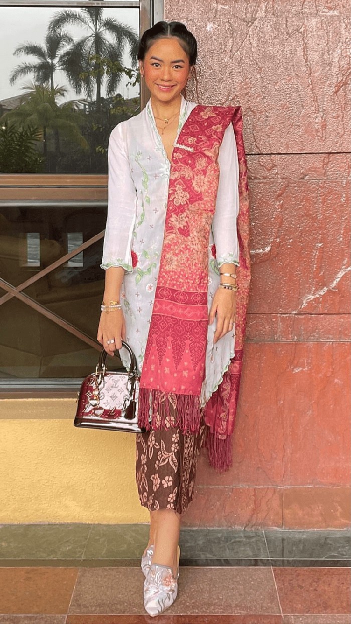 Sering ditemukan pakai kebaya, penampilan Rania Maheswari Yamin dalam kebaya Jawa putih selendang merah jambu, serta kain 3/4 tak kalah memesona. Aksesori sederhana, yaitu layer kalung, anting, dan gelang ikut terkombinasi. Foto: instagram.com/raniaayamin