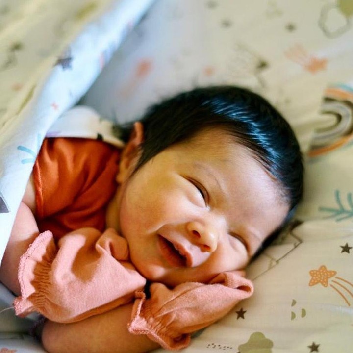 <p>Meski masih bayi, baby Mikhaila punya senyum yang manis lho Bunda. Melihat pipinya yang chubby, duh rasanya jadi enggak tahan ya pingin gendong. (Foto: Instagram @eriskarien)</p>
