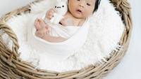 <p>Seperti bayi lainnya, baby Mikhaila juga pernah menjalani sesi pemotretan saat usianya baru 14 hari. Ia terlihat sangat tenang memgang boneka dalam balutan kain putih. (Foto: Instagram @eriskarien)</p>