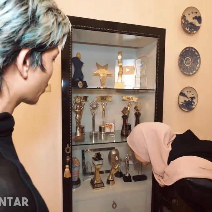 <p>Di ruang keluarga, Bella juga memiliki lemari yang berisi beragam penghargaan yang telah diraihnya selama menyelami industri hiburan. (Foto: YouTube AH)</p>
