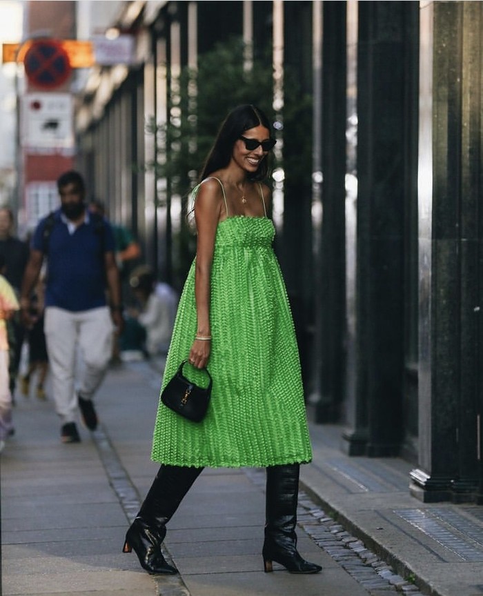 Warna hijau yang difavoritkan langsung jadi pusat perhatian ketika disandingkan warna gelap. Contohnya summer dress hijau yang makin mencolok saat digabungkan tas, leather boots, dan sun glasses hitam. Foto: instagram.com/cphfw/Anastasia