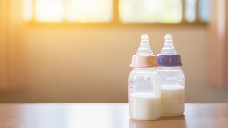 Ilustrasi Merek Susu Formula Bayi Baby bottle with milk and a measuring scale on the background of a lot of full bottles of breast milks, the most healthy food for newborn,vintage color