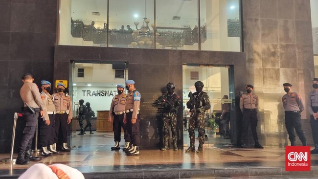 Anggota Brimob berada di halaman Gedung TNCC Divisi Propam Polri, Jakarta Selatan. Mereka membawa senjata laras panjang serta memakai helm pelindung.