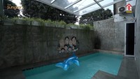 <p>Tembok yang berada tepat di pinggir kolam renangnya juga cukup unik. Pasalnya mereka menghiasi tembok tersebut dengan lukisan wajah keluarganya, lho, Bunda. Kreatif sekali, ya, Bunda. (Foto: YouTube The Sungkars)</p>