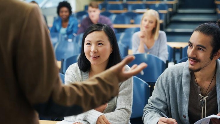 Rearview shot of a teacher talking to his university students