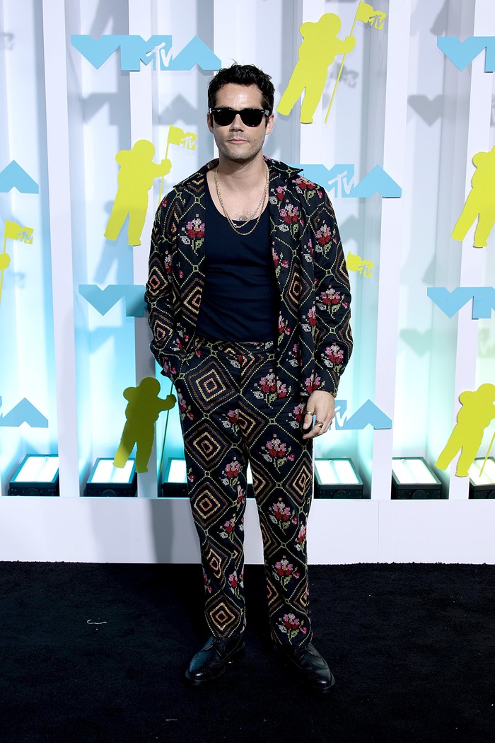 Aktor Dylan O'Brien juga berani tampil beda di MTV VMA 2022. Saat setelan jas penuh warna jadi tren, ia memilih kombinasi jaket dan celana penuh detail dari label Bode. Swag! Foto: Getty Images for MTV/Paramount G/Dimitrios Kambouris