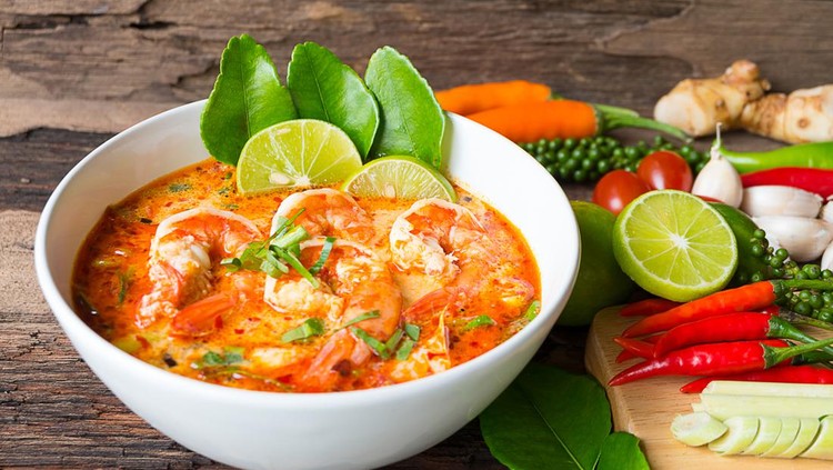 Hot and sour soup Traditional food in Thailand contains chili  lime  ginger galangal, lemongrass, lime leaf on old wood floor