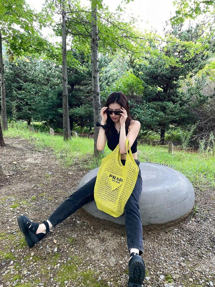 Makin keren, Sana TWICE juga hangout dengan tote bag kuning dari Prada. Dengan outfit serba hitam, Sana OOTD dengan latar pepohonan. Tote bag ini cocok dipakai saat musim panas. Beauties tertarik mencoba?/ Foto: instagram.com/m.by__sana