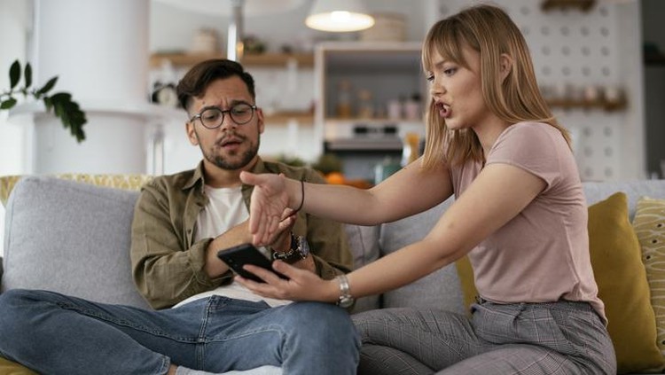 1270411166 Boyfriend and girlfriend are arguing on the couch. Angry woman is yelling at her boyfriend.