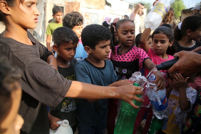 Palestinian children wait to fill bottles with drinking water, in a poor neighborhood in Beit Lahia in the northern Gaza Strip, on 01 September 2022.
 (Photo by Majdi Fathi/NurPhoto via Getty Images)