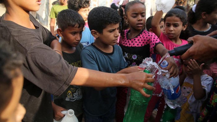 Palestinian children wait to fill bottles with drinking water, in a poor neighborhood in Beit Lahia in the northern Gaza Strip, on 01 September 2022.
 (Photo by Majdi Fathi/NurPhoto via Getty Images)