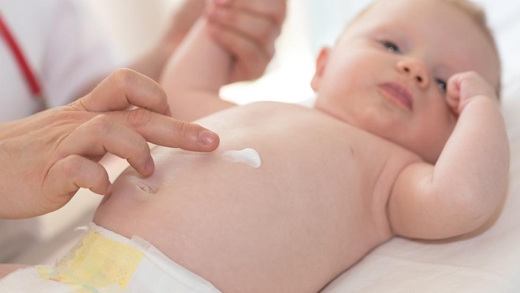 Ilustrasi Tips Memilih Skincare untuk Bayi Kulit Sensitif Hand of pediatrician applying cream on baby body