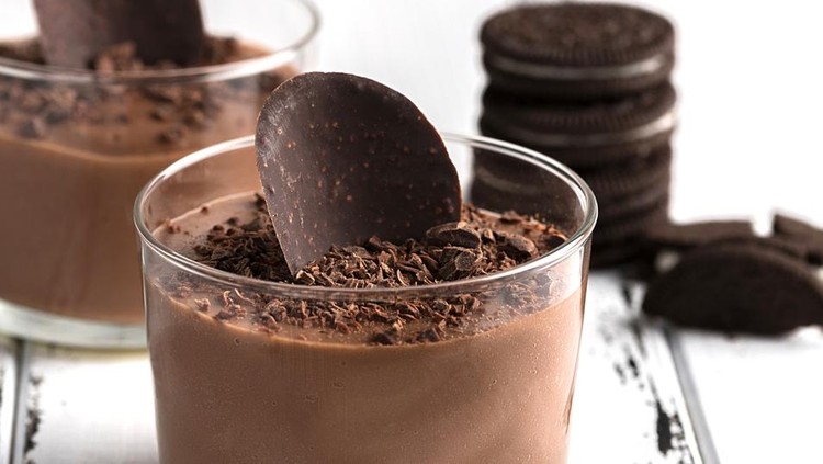 908582112 Chocolate mousse in a glasses on a white wooden background.