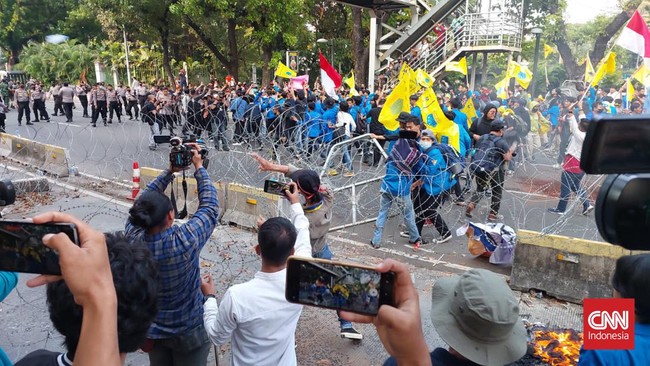 Diselingi teriakan revolusi dari orator, massa merusak kawat berduri yang dipasang aparat kepolisian.