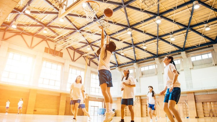 Ilustrasi Sekolah Khusus Olahraga di Indonesia Japanese Junior High School girl friends playing basketball in the School GYM.