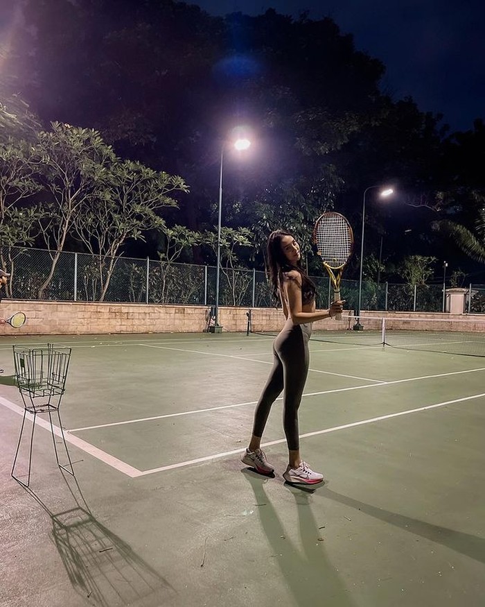 Influencer dan juga aktris, Anya Geraldine juga mencoba olahraga tenis ini. Bermain di malam hari, Anya mengenakan sport bra dipadukan dengan legging sport yang membentuk lekuk tubuhnya. / foto: Instagram.com/anyageraldine
