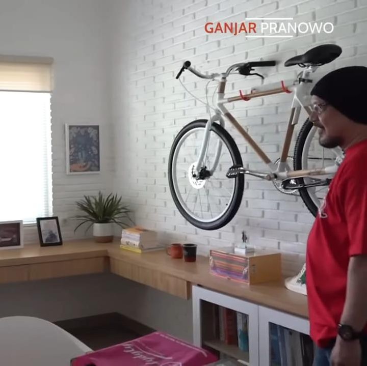 <p>Rumah yang mendapat julukan "White House De Noyas" ini memiliki konsep serba putih dengan desain minimalis. Ini adalah potret ruang kerja Andy yang sangat unik, pasalnya ia meletakkan sepeda favoritnya di dinding. (Foto: YouTube Ganjar Pranowo)</p>