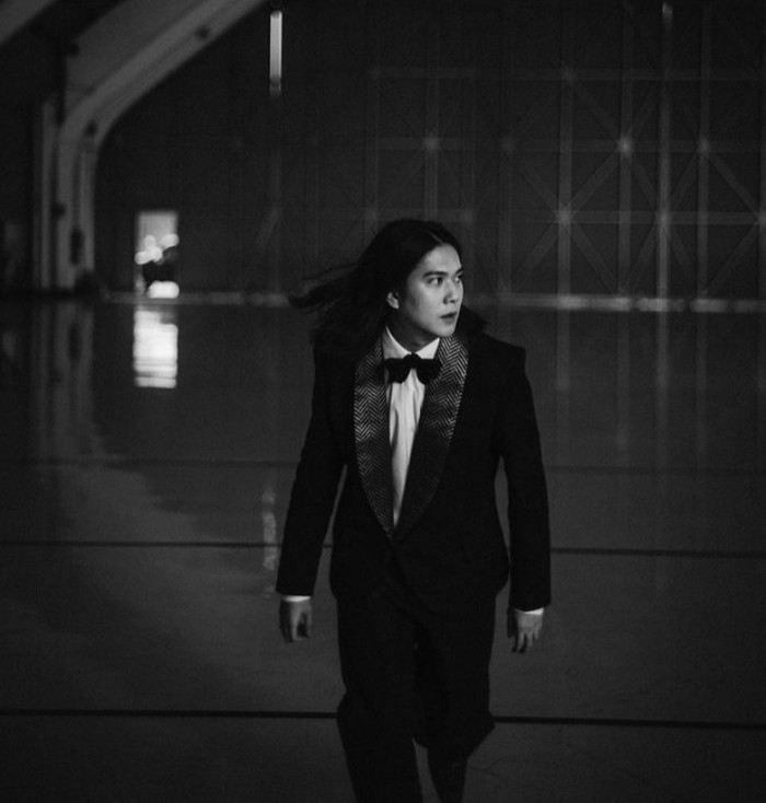Dalam foto bernuansa hitam putih, Iqbaal begitu memesona dengan balutan Songket Collar Tux milik Didit Hediprasetyo dalam koleksi Fall/Winter 2022-2023 dan rambut gondrongnya yang dibiarkan terurai. (Foto: Instagram @iqbaal.e)