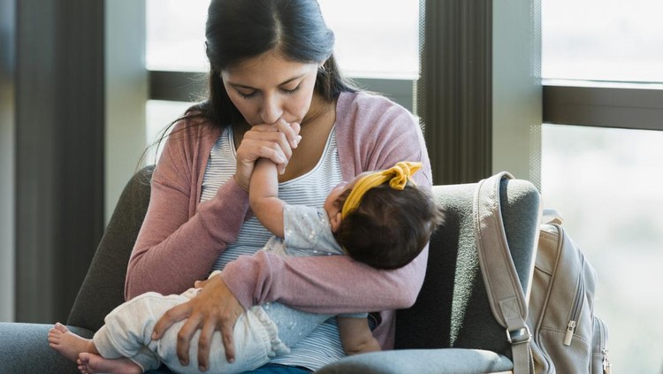 As she waits in the psychiatrist's office, the new mom closes her eyes as she kisses her baby's hand.