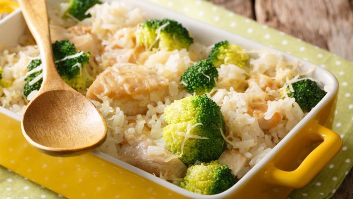 Homemade rice with broccoli, chicken, garlic and cheese close-up in a baking dish on a table. horizontal
