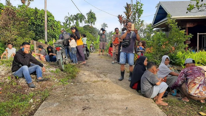 Warga berkumpul di luar rumah mereka setelah gempa bumi di Kepulauan Mentawai Indonesia, di desa Muara Sikabaluan di Siberut Utara, provinsi Sumatera Barat, Minggu (11/9/2022). (Photo by BAMBANG SAGURUNG/AFP via Getty Images)