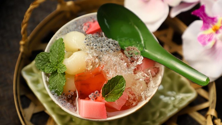 1314522033 Ice Longan Jelly, an icy dessert of strawberry milk agar and strawberry jelly cubes with preserved longan fruits with its syrup. Some crushed ice and basil seeds are added to the dish; then garnished with mint leaves.