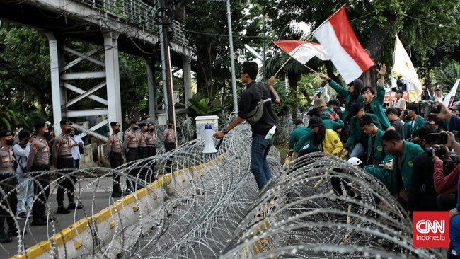 Polisi mengamankan dua orang saat demo menolak kenaikan BBM yang dilakukan massa GNPR hingga mahasiswa di Patung Kuda Arjuna Wijaya, Jakarta.