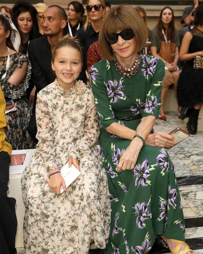 Harper Seven menyaksikan peragaan busana rumah mode rintisan ibunya. Duduk di sebelah Anna Wintour, mereka kompak pakai maxi dress flora. Foto: instagram.com/victoriabeckham