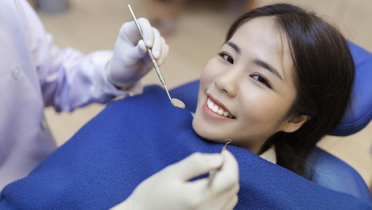 Closeup smile of woman having dental teeth examined dentist check-up via excavator in Clinic her patient