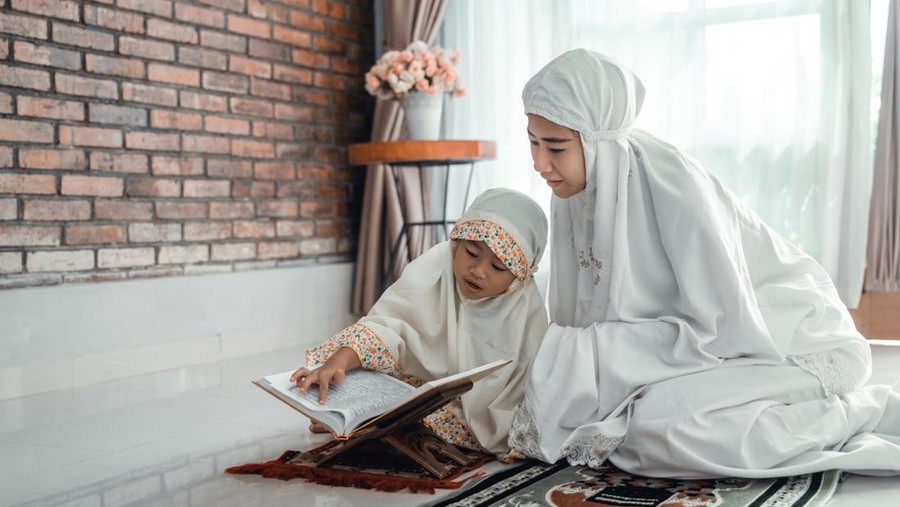 mother and kid reading quran together at home
