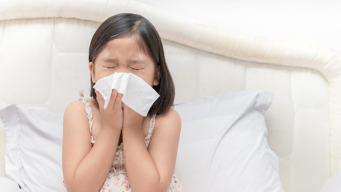 Asian girl blowing the nose by tissue, health care and sick concept