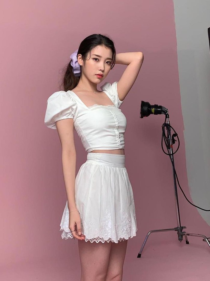 Aktris sekaligus penyanyi, IU, tampil manis dan chic dalam balutan outfit crop top dan rok dengan nuansa serba putih. Gaya low ponytail pada rambutnya pun turut memberi kesan feminin./ Foto: instagram.com/dlwlrma