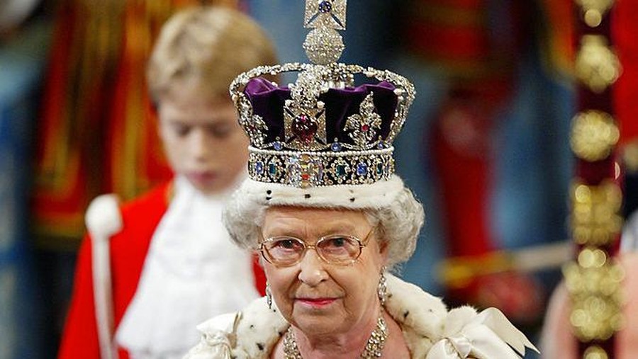Britain's Queen Elizabeth II, wearing the Imperial Crown, walks in procession through The Royal Gallery on her way to give her speech during the ceremonial state opening of Parliament in London 13 November 2002. WPA POOL