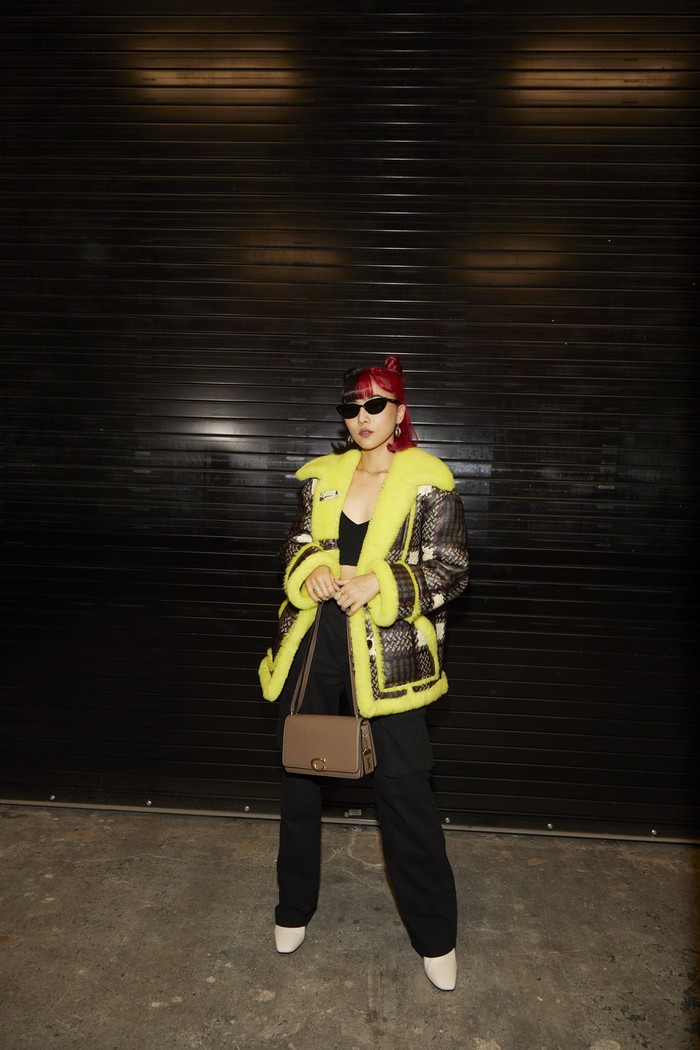 Untuk penampilannya saat menonton New York Fashion Week, Isyana memilih padanan jaket oversized neon detail shearling lansiran label Amerika Serikat tersebut. Dipadukan dengan celana hitam, sunglasses, dan tas Coach Bandit. Foto: Coach