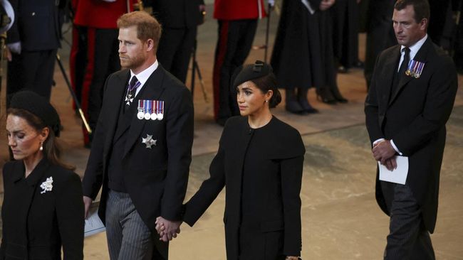 Pangeran Harry dan Meghan Markle berpegangan tangan saat menghadiri prosesi persemayaman Ratu Elizabeth II di Westminster Hall, Inggris.