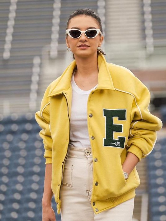 Raline Shah juga menjadi salah satu artis Indonesia yang berangkat ke New York bersama brand Erigo. Saat menonton final US Open, Raline terlihat edgy memakai jaket kuning dan kacamata bergaya cat eye. (Foto: Instagram @ralineshah)