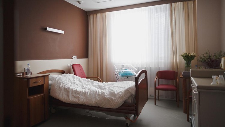 1171595635 Empty modern room with a comfortable bed and a ditch for the baby in the maternity hospital