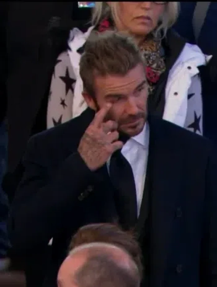 Menurut Lizzy Lloyd pada cuitan di akun Twitter via PageSix, teman ibunya ada di depan Beckham persis dan sama sepertinya telah mengantre. Ia juga mengatakan Beckham setuju akan foto bersama tapi usai dirinya melayat Ratu. Ia tampak sedang mengusap air mata di wajahnya. /Foto: Anadolu Agency via Getty Images/Anadolu Agency