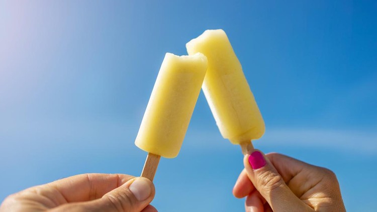 1270258761 Hands Holding Popsicles Against Blue Sky